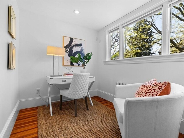 office space with baseboards, a healthy amount of sunlight, and wood finished floors