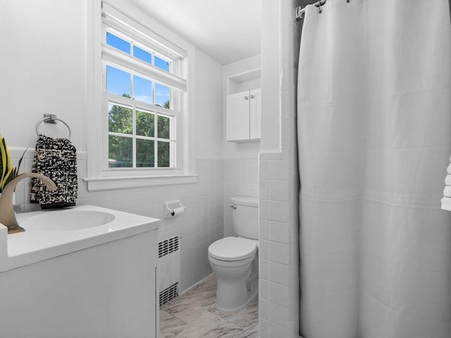 full bath featuring tile walls, vanity, toilet, marble finish floor, and radiator heating unit