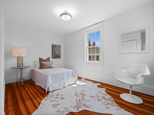 bedroom with baseboards and wood finished floors