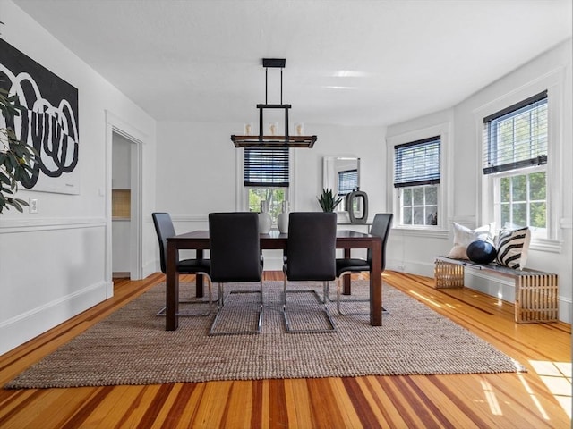 dining room with baseboards, wood finished floors, and a chandelier