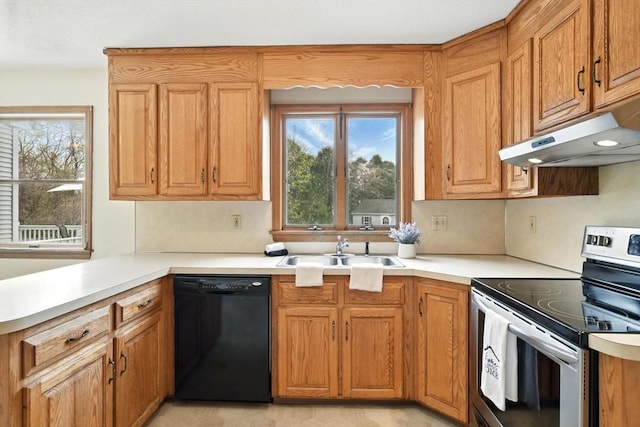 kitchen featuring electric range, dishwasher, a sink, under cabinet range hood, and a wealth of natural light