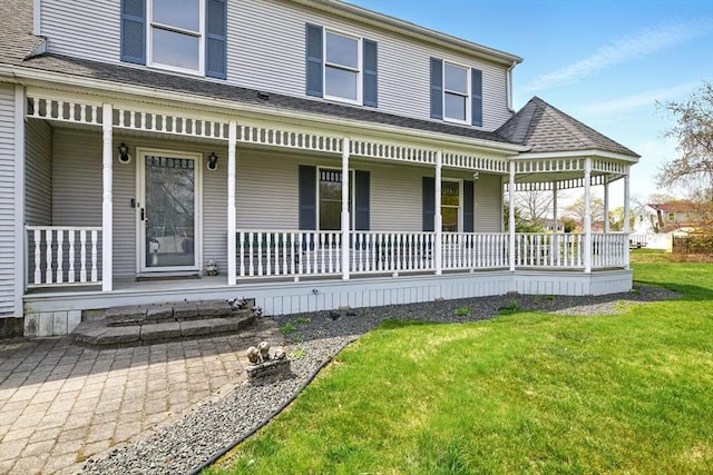 exterior space featuring a lawn and covered porch
