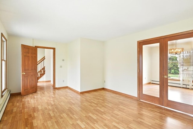 empty room with baseboard heating, a chandelier, light wood-style flooring, baseboards, and stairway