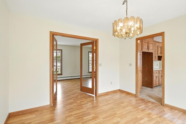 empty room featuring an inviting chandelier, baseboards, a baseboard heating unit, and light wood-style flooring