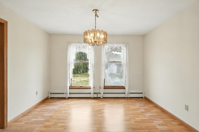 unfurnished dining area featuring baseboards, a notable chandelier, baseboard heating, and light wood finished floors
