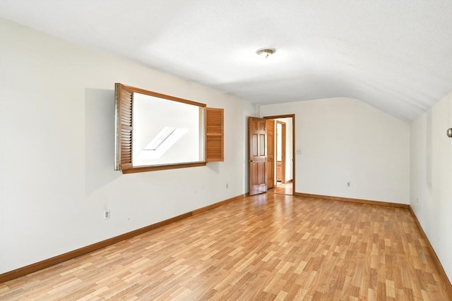 bonus room featuring baseboards, vaulted ceiling, and light wood-type flooring