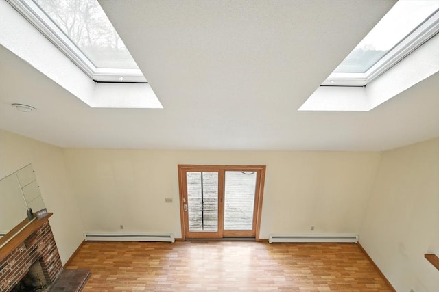 unfurnished living room featuring a baseboard radiator, a fireplace, wood finished floors, and a skylight