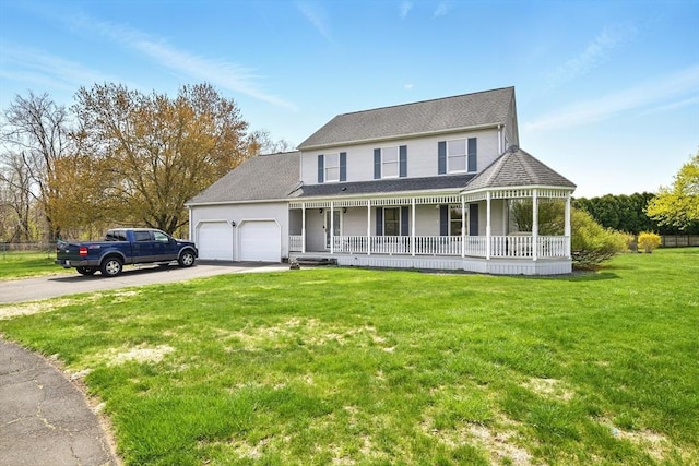 farmhouse inspired home featuring covered porch, a garage, a front yard, and aphalt driveway