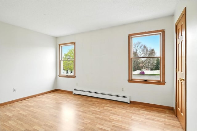 unfurnished room featuring baseboards, light wood finished floors, and baseboard heating