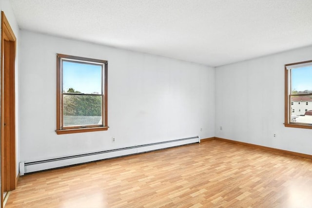 unfurnished room with a textured ceiling, baseboards, light wood finished floors, and a baseboard radiator