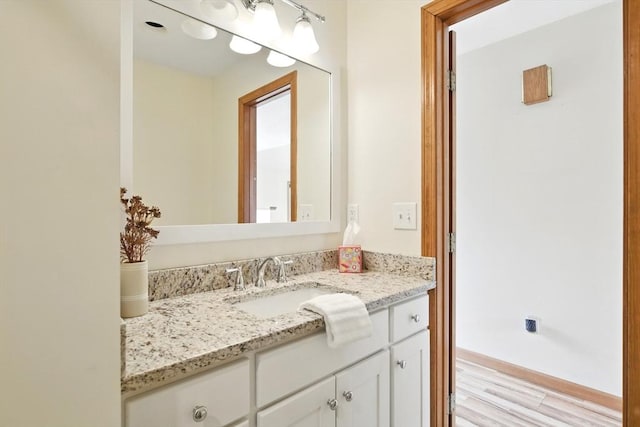 bathroom with vanity, baseboards, and wood finished floors