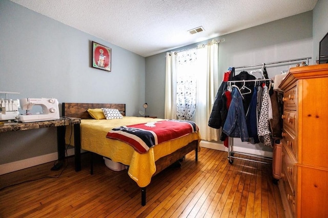 bedroom with hardwood / wood-style floors and a textured ceiling