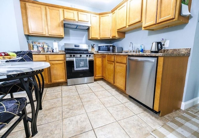 kitchen with light tile patterned floors, stainless steel appliances, and sink