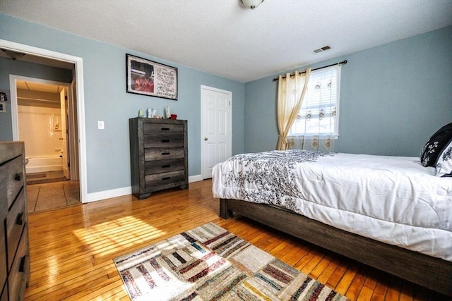 bedroom featuring hardwood / wood-style flooring and a textured ceiling