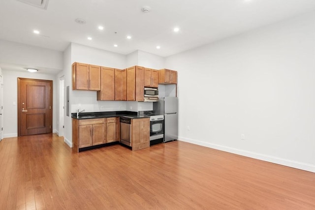 kitchen with sink, light hardwood / wood-style flooring, and stainless steel appliances