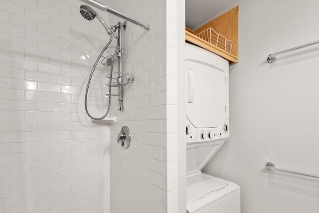 bathroom featuring stacked washer / drying machine and tiled shower