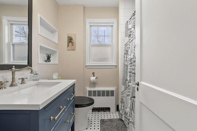 full bathroom with toilet, vanity, and radiator heating unit