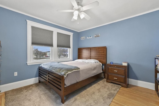 bedroom with crown molding, ceiling fan, light wood-style flooring, and baseboards