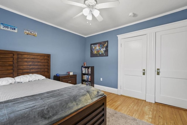 bedroom with ornamental molding, a ceiling fan, light wood-style flooring, and baseboards