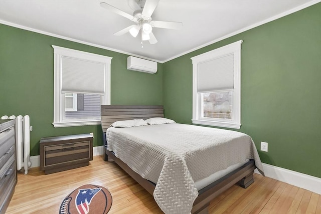 bedroom featuring ornamental molding, wood finished floors, baseboards, and a wall mounted AC