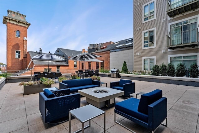 view of patio featuring a balcony, grilling area, and an outdoor living space with a fire pit