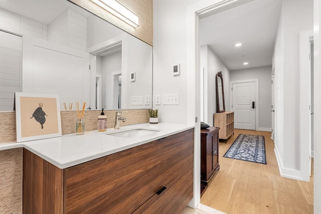 bathroom featuring wood-type flooring, backsplash, and vanity