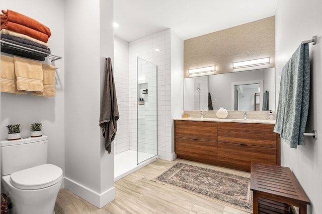 bathroom with vanity, hardwood / wood-style floors, toilet, and a shower with door