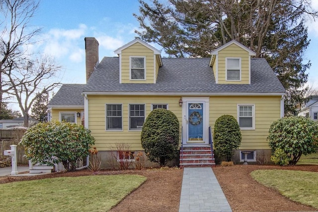 cape cod house featuring a front yard