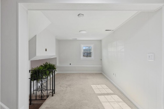 carpeted spare room with visible vents and baseboards