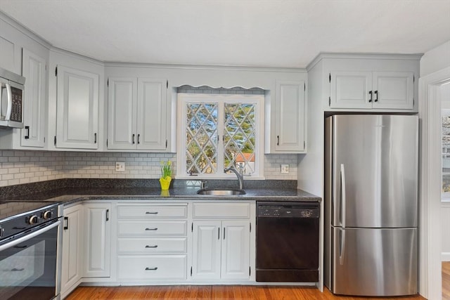 kitchen featuring white cabinets, stainless steel appliances, and a sink