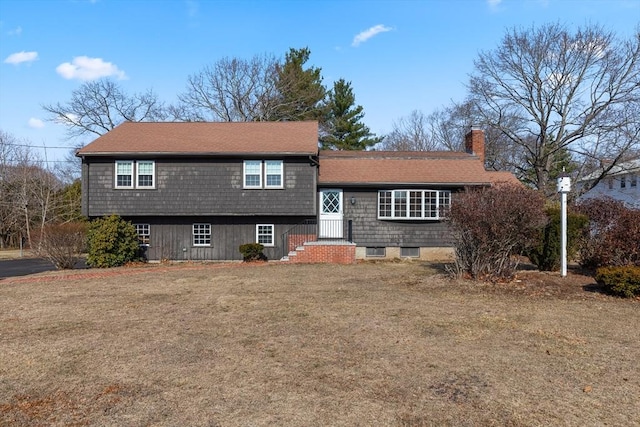 tri-level home with a front lawn and a chimney