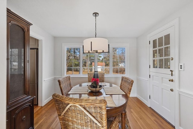 dining room featuring light wood finished floors and baseboards