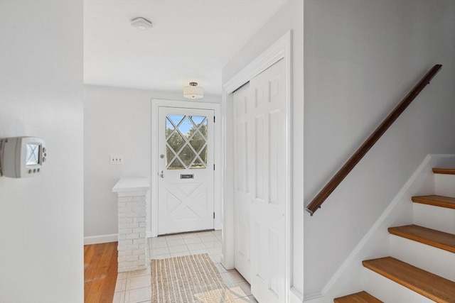 doorway to outside with stairs, tile patterned floors, and baseboards