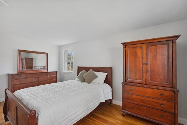 bedroom with baseboards and wood finished floors