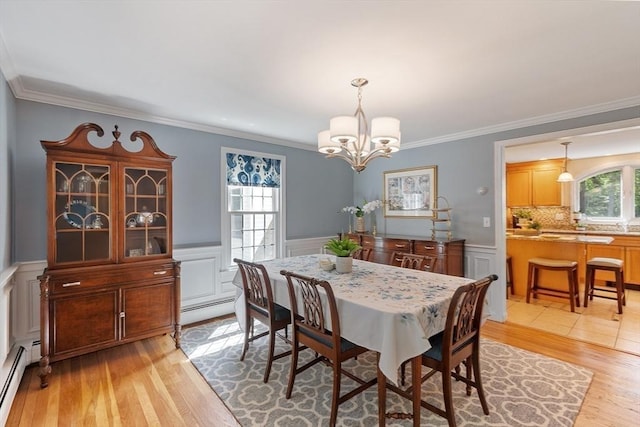 2 Pomfret Rd, Chelmsford, MA 01824 - dining room with baseboard heating, light wood-type flooring, a chandelier, crown molding, and a wainscoted wall