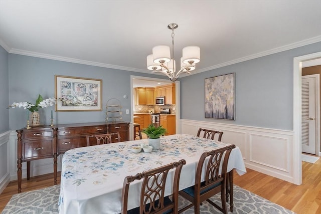2 Pomfret Rd, Chelmsford, MA 01824 - dining space with light wood-type flooring, a chandelier, ornamental molding, wainscoting, and a decorative wall