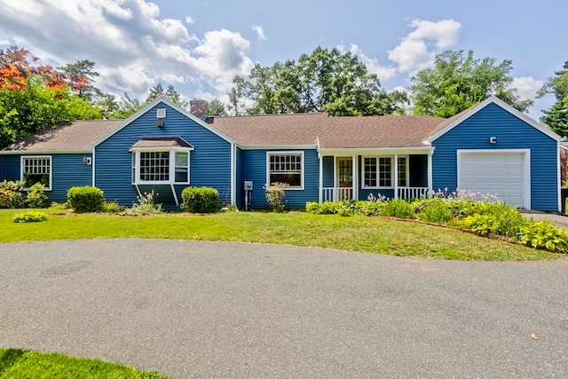 ranch-style home featuring a garage and a front lawn