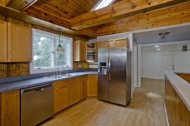 kitchen with pendant lighting, sink, stainless steel appliances, lofted ceiling with beams, and light wood-type flooring