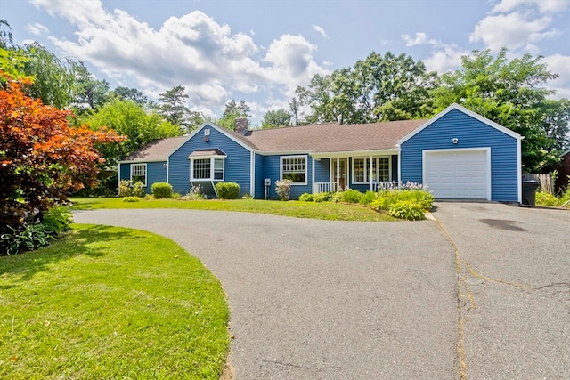 ranch-style home featuring a garage, a porch, and a front lawn