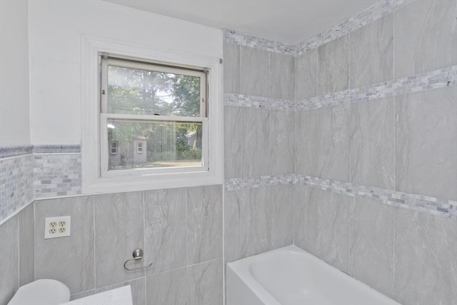 bathroom featuring tile walls and bathtub / shower combination