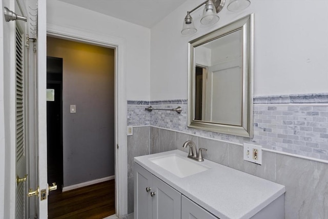 bathroom featuring vanity, hardwood / wood-style floors, and tile walls