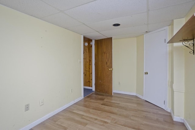 empty room with a paneled ceiling and light hardwood / wood-style flooring