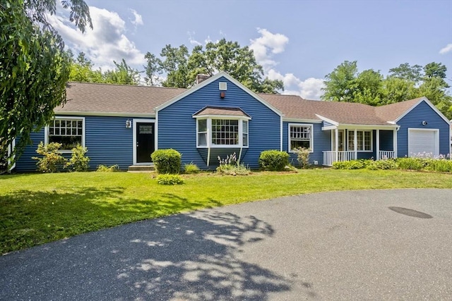 ranch-style house with a garage, a front yard, and a porch