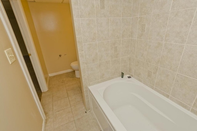 bathroom with toilet, a bathing tub, and tile patterned flooring