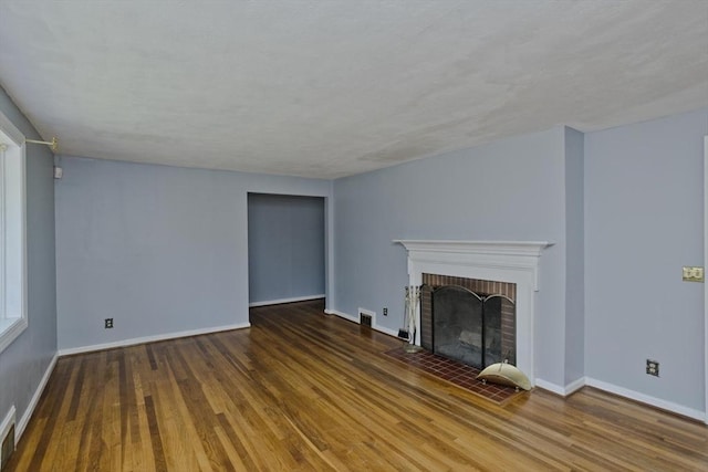 unfurnished living room featuring a fireplace and dark hardwood / wood-style flooring