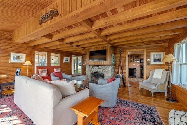 21 Glenwood St, Yarmouth, MA 02673 - living area with a fireplace, a wood ceiling with exposed beams, wood finished floors, plenty of natural light, and wooden walls