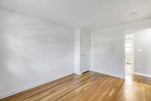 empty room with light wood finished floors and baseboards