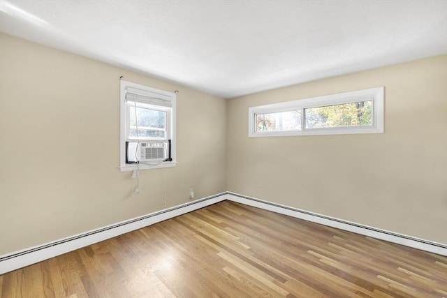 empty room with a baseboard radiator, cooling unit, plenty of natural light, and wood finished floors