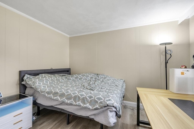 bedroom featuring ornamental molding and wood finished floors