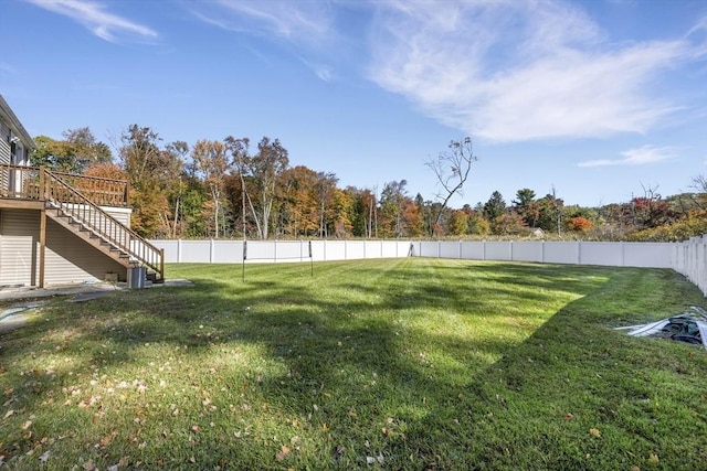 view of yard with a fenced backyard, stairs, and a deck